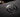 Extreme macro shot of a premium business card with a glossy Spot UV logo on a matte black surface
