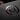 Extreme macro shot of a premium business card with a glossy Spot UV logo on a matte black surface