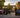 A professional and welcoming school entrance featuring vibrant outdoor banners and a clear sign-in station, shot in high-reso